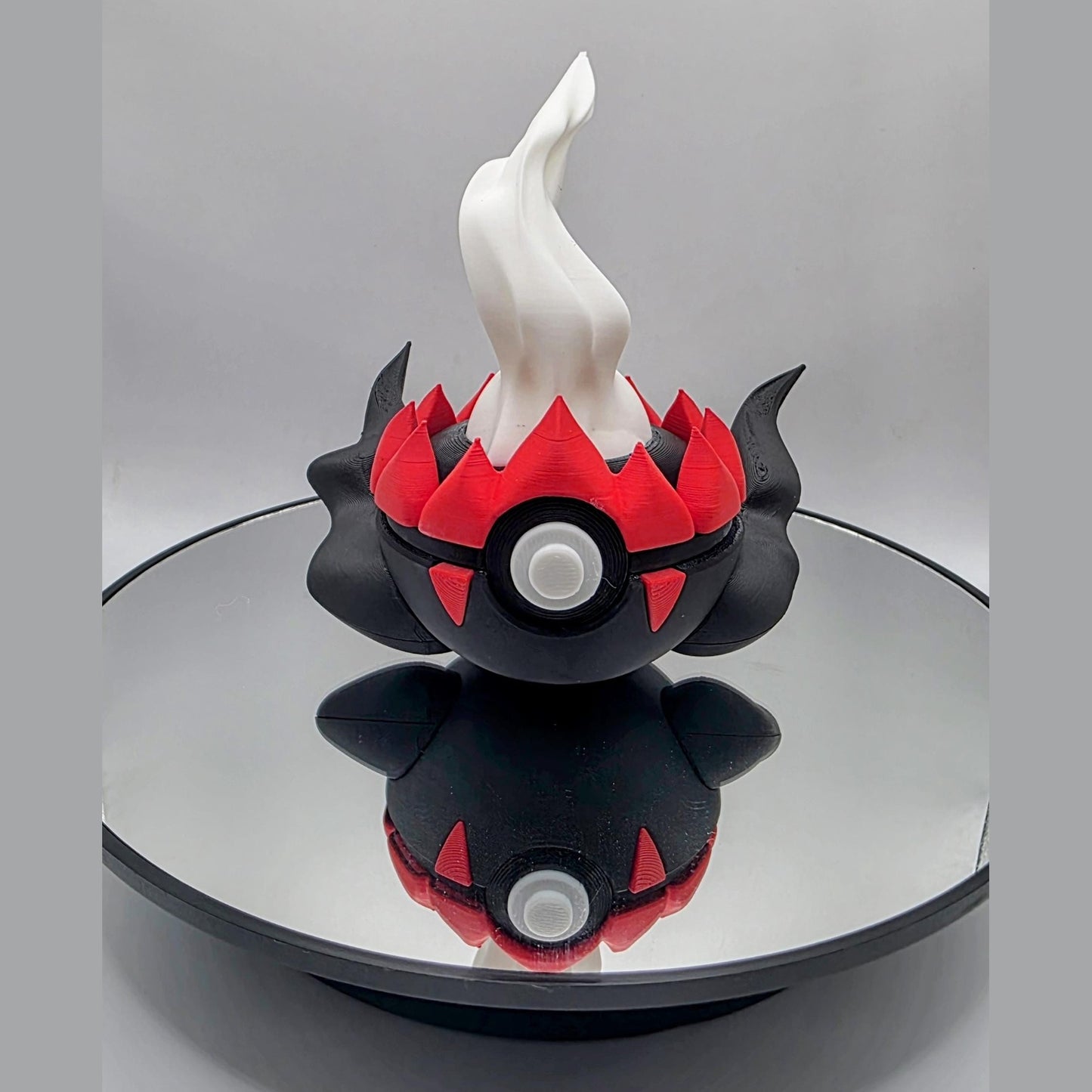 3D printed black shadowed flame creature ball with white rising flame accent