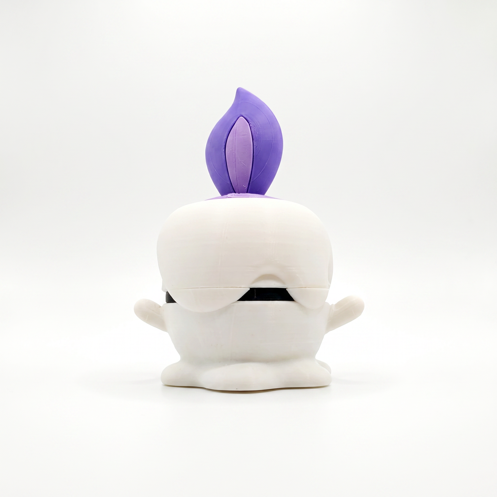 Close up of the creature ball showing white melted wax body with rounded drip base and stubby arm detail